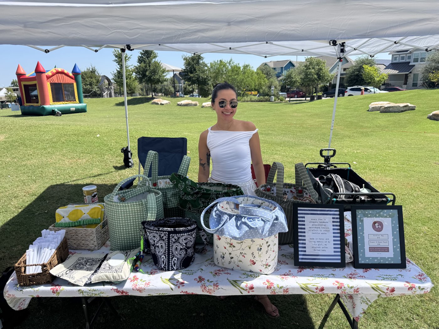 Amy at her Polka Dot Dog Studio booth, table full of handmade bags under a market tent